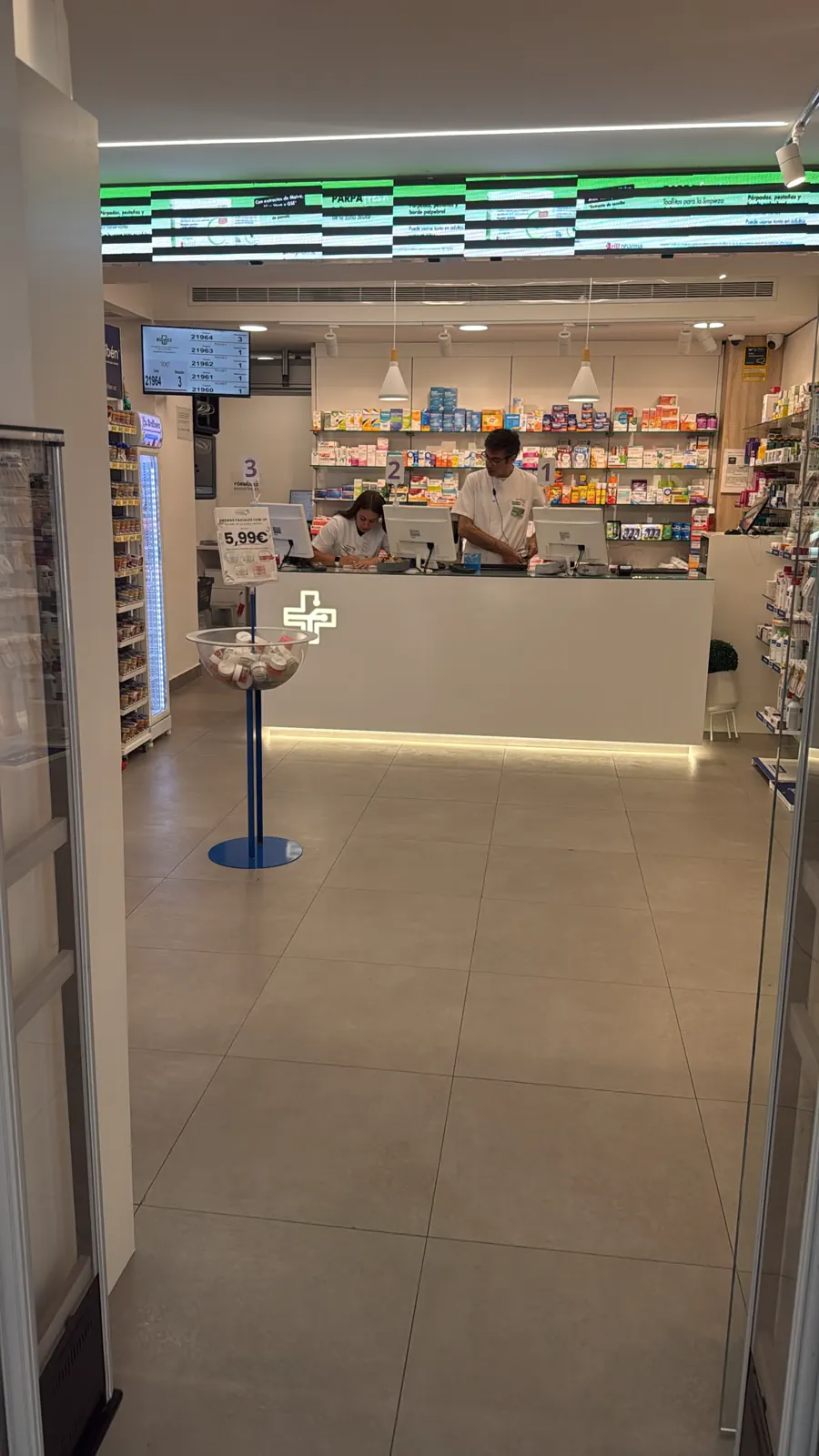 L'ingresso della farmacia, con vista sul banco e sul personale al lavoro